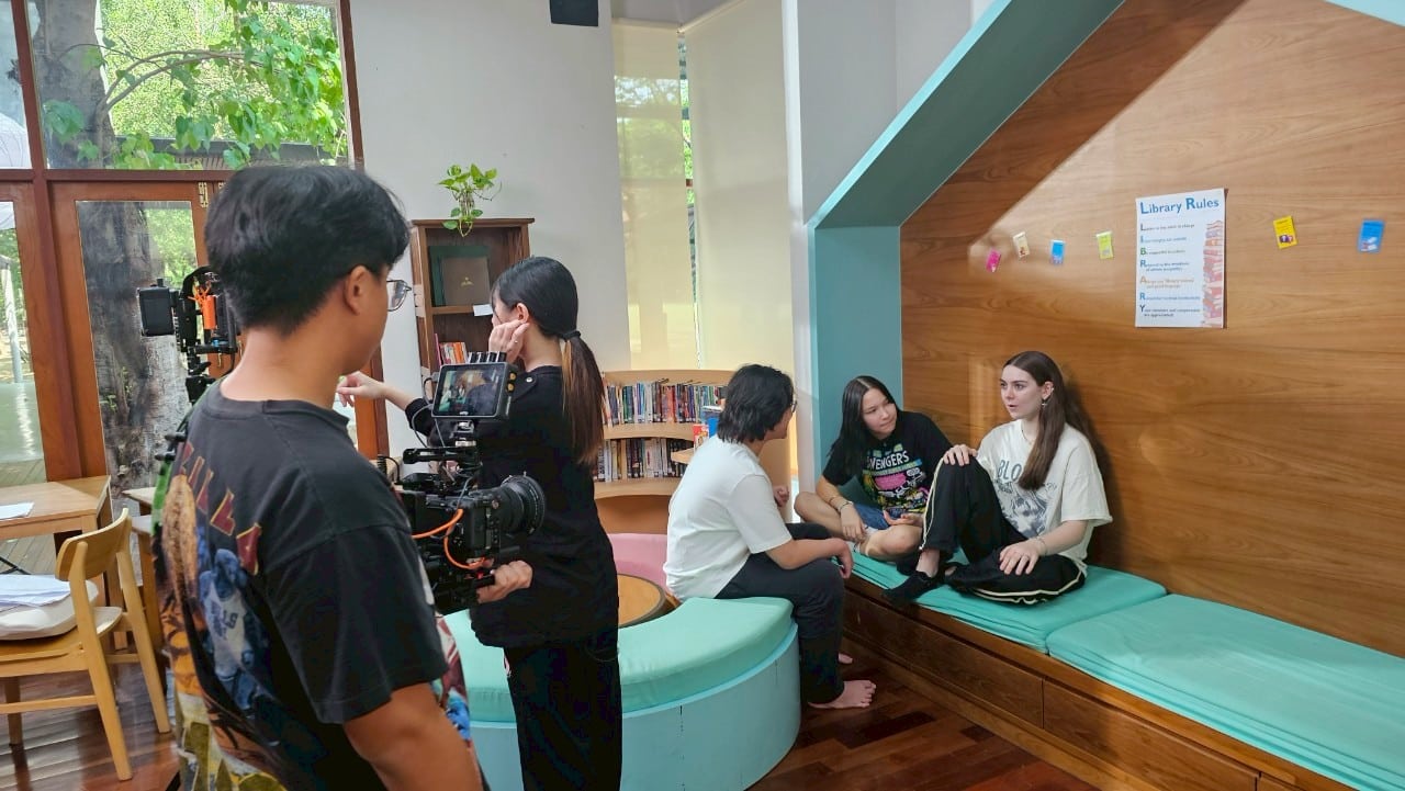 Multicultural model posing confidently on a Thailand set, highlighting talent.  

